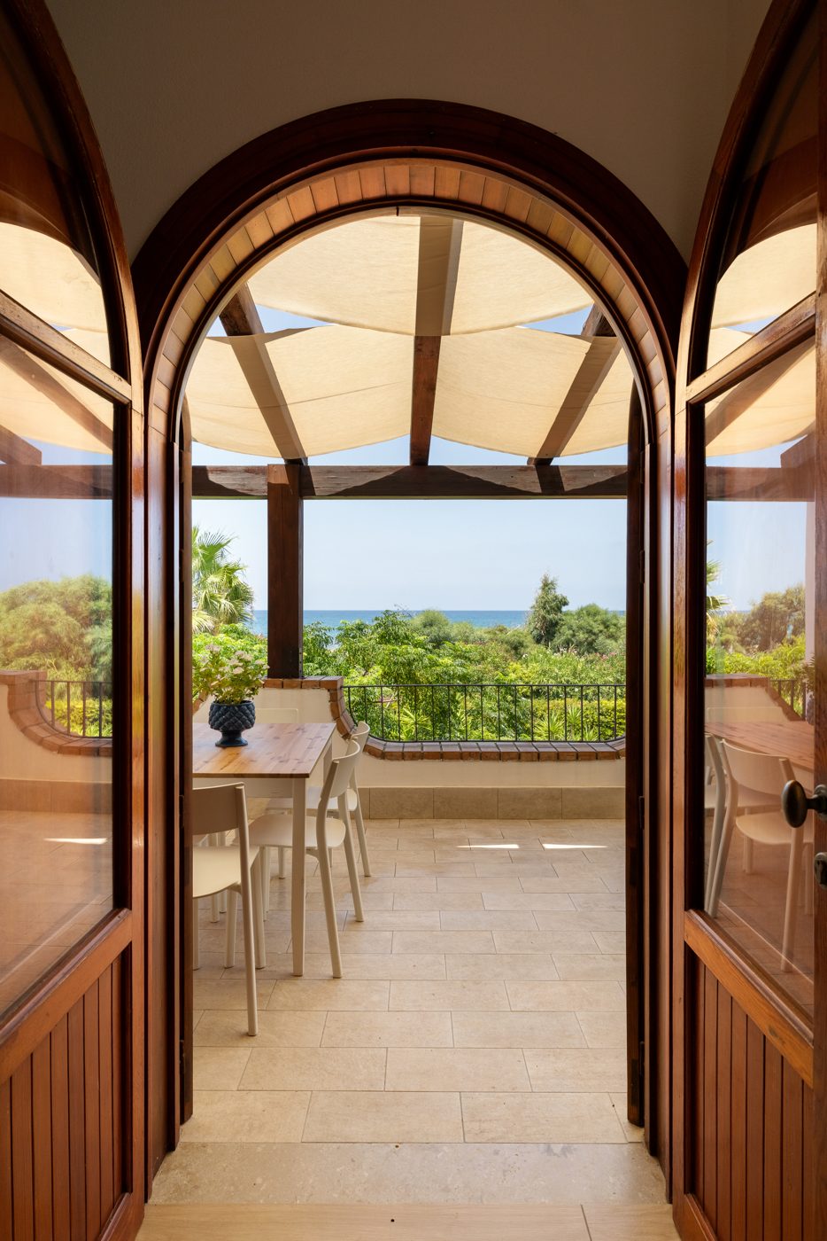 Porta ad arco che si apre dall'interno sulla terrazza con vista sul giardino