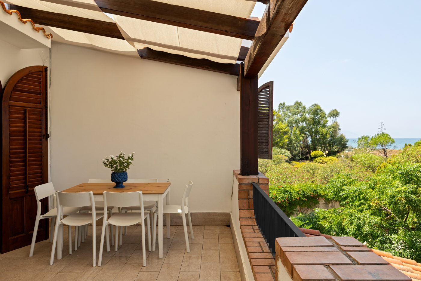 Terrazza coperta con tavolo e vista sul giardino